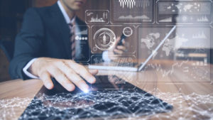 Man using tablet with overlaying data illustrations